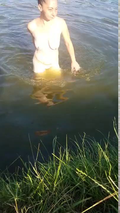 Красивая женщина купается без купальника в реке – сцена из фильма «Американец» (2010)